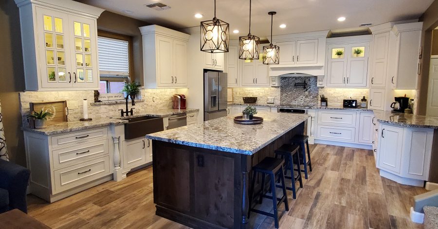 Modern kitchen interior featuring white cabinetry, granite countertops, pendant lighting, and a spacious island, illustrating contemporary design trends in home remodeling.
