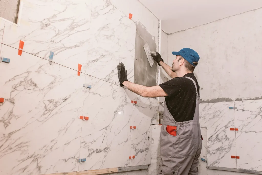 Professional tile installation Denver bathroom remodeling services - Expert craftsman installing premium marble tile with precision tools and techniques
